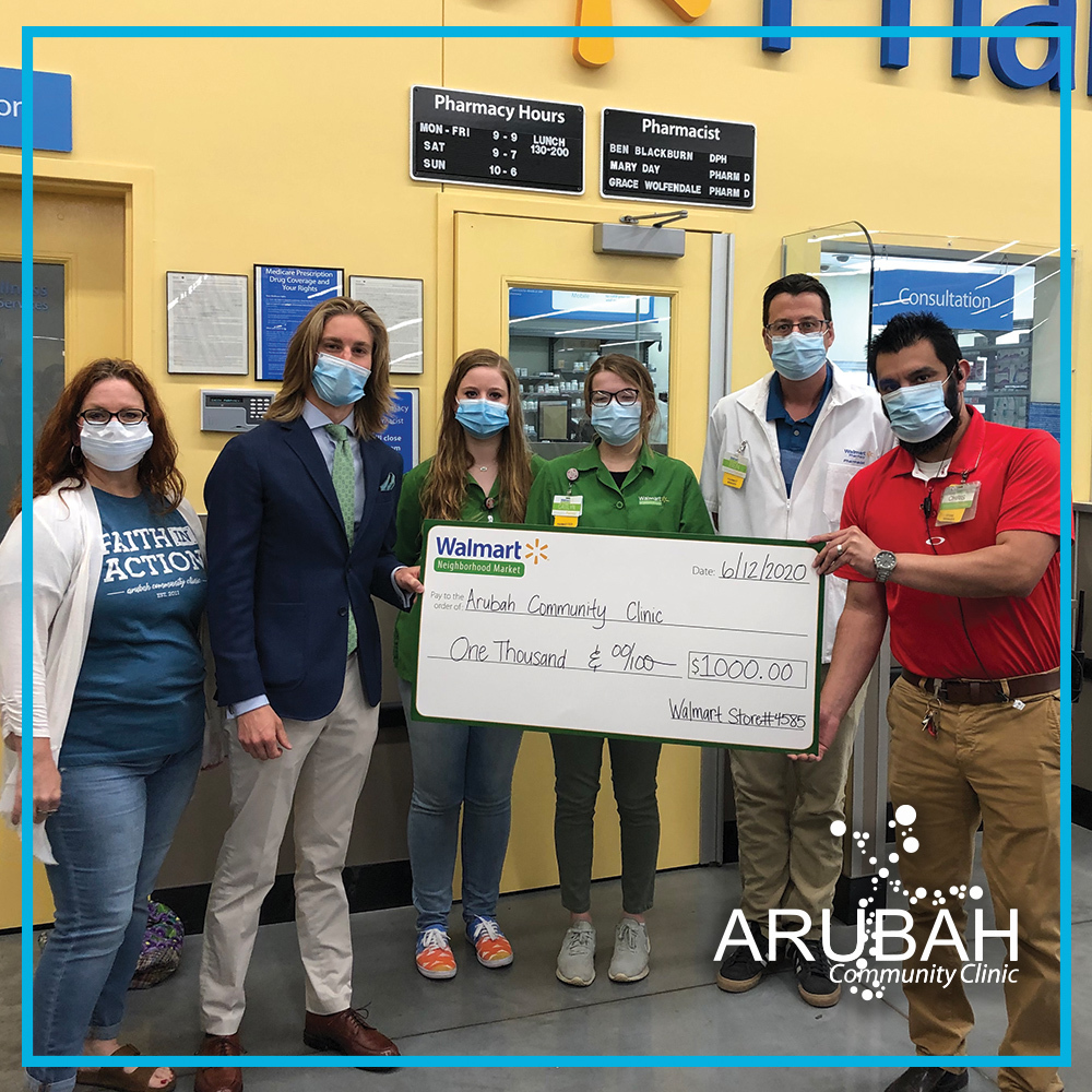 Walmart employees present Arubah Community Clinic Staff a one thousand dollar check through the Walmart Local Community Grant program.